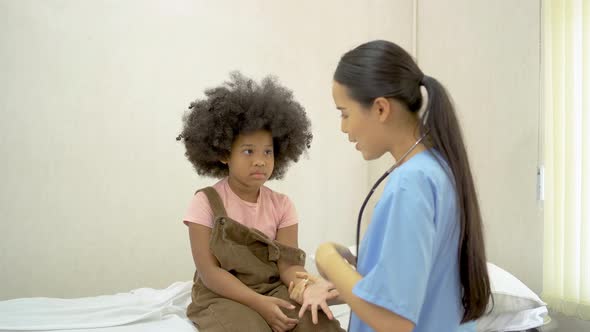 Female doctor doing physical examination on small girl with fracture