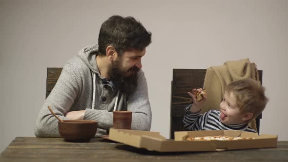 Dad and Kid Eating Pizza