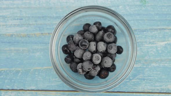 Defrosting Frozen Blueberry. Timelapse of Unfreezing, Ice Melting of Fruits, Berries on Glass Plate