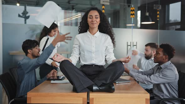 Young Hispanic Woman Sitting on Table in Lotus Position Female Leader Meditating in Office