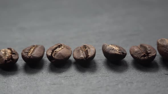 Coffee Beans Lie in Row on Stone. The Camera Slowly Fly Left Over Coffee