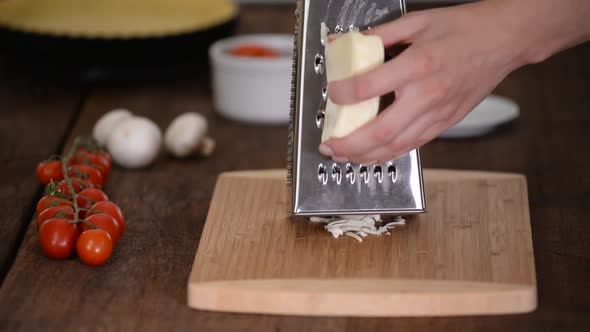 Woman Grating Cheese on Wooden Table