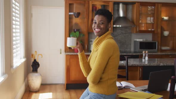 Portrait of african american woman drinking coffee at home