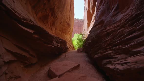 Hiking out from within narrow slot canyon in the Utah desert