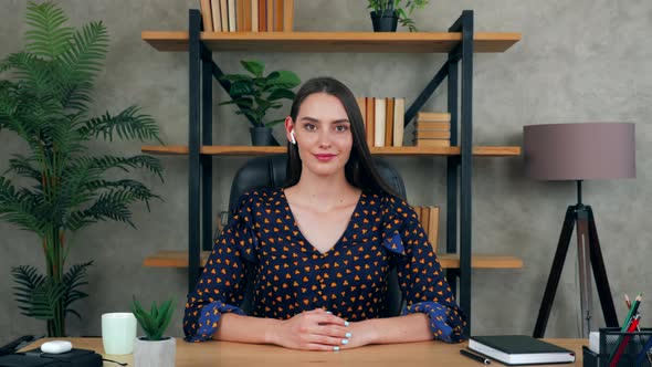 Smiling beautiful businesswoman in home office listen interlocutor on video call chat conference