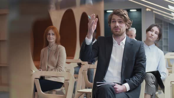 Portrait of Caucasian Man Asking Question during Seminar