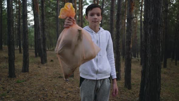 Volunteer Showing Garbage Bags After Cleaning Forest