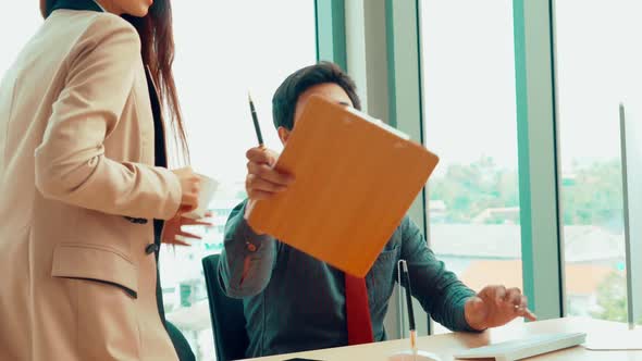 Two Business People Talk Project Strategy at Office