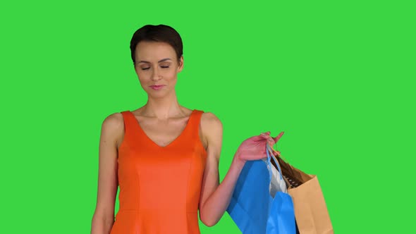 Woman Posing on Camera with Multicolored Shopping Bags on a Green Screen, Chroma Key