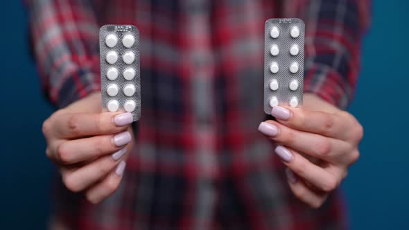 Woman Presenting a Hand of Foil-wrapped Pills