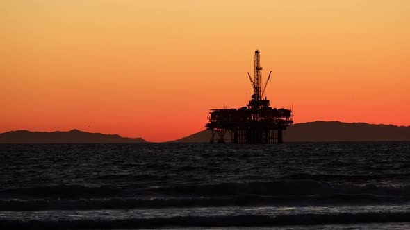 The sun setting behind an offshore oil platform