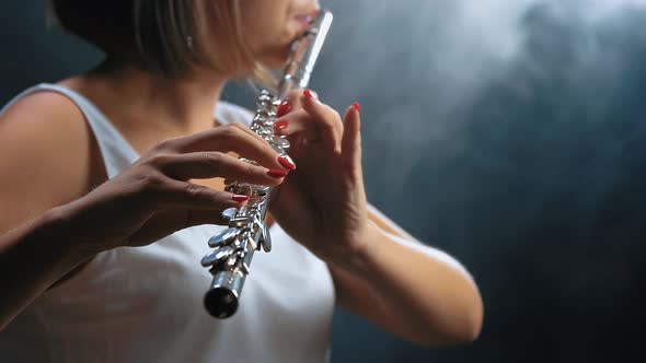 Professional Musician Female Playing on Flute. Smoky Studio