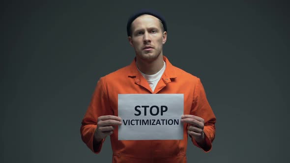 Caucasian Prisoner Holding Stop Victimization Sign Treatment in Jail