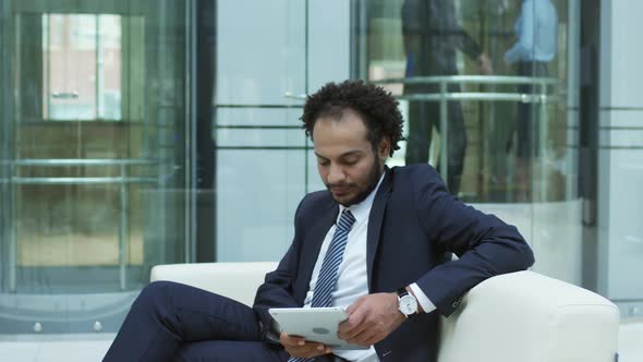 Middle Eastern Entrepreneur Using Tablet in Business Center