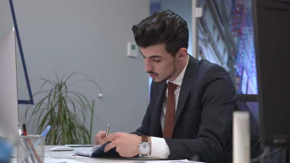 Businessman writing at his desk