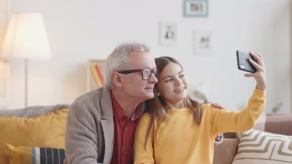 Caucasian Girl and Granddad Taking Selfies on Smartphone