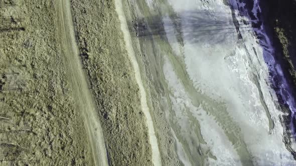 Drone shot of the forest and a country icy river in the late autumn. Late Autumn forest hills. Aeria