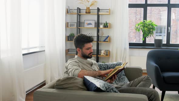 Man Reading Book and Drinking Coffee at Home