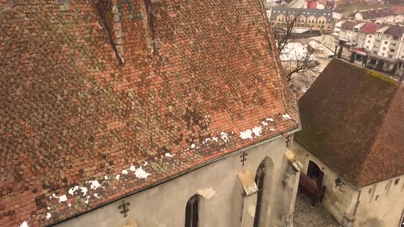 A drone shot, with forward motion, capturing a glimpse of the city of Sighisoara on an afternoon