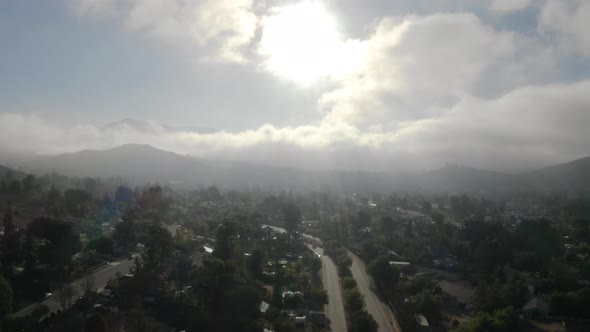 Aerial view of low fog over mountains in San Diego during sunrise