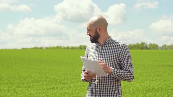 Agronomist or Farmer Examines Soybean Growth