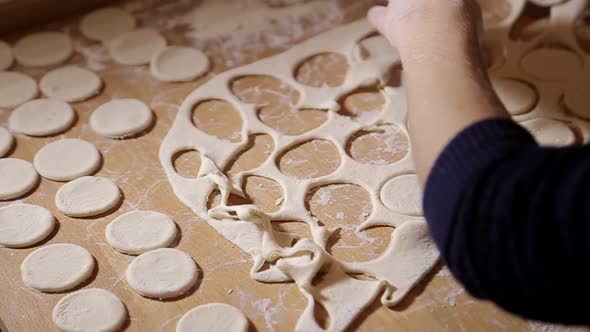 Woman molds dough at home. Roll out the dough with a rolling pin