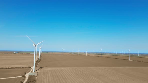 Aerial View of Wind Turbine Farm on Agriculture Fields in Ukraine on Clear Blue Sky Background