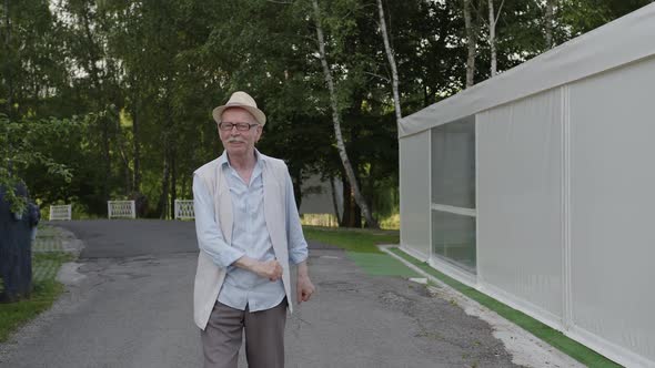 Old Man Finished Dancing and Slowly Walk on the Path