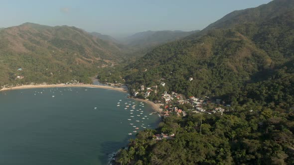 Bungalows And Boats At The Beachfront Of Yelapa Town Resort With Towering Forest Mountains In Jalisc
