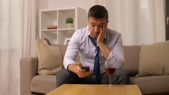 Alcoholic with Smartphone Drinking Wine at Home