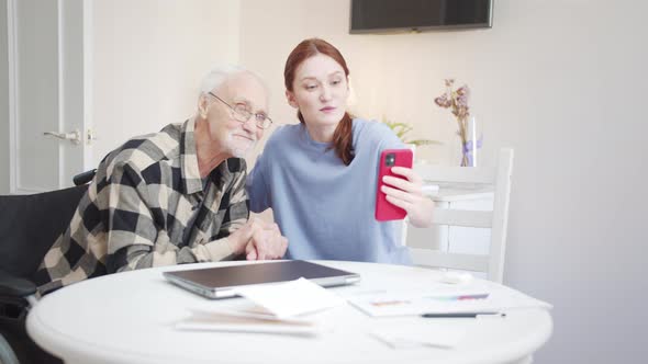 Woman and Old Man Communicate with Relatives Via Video Call