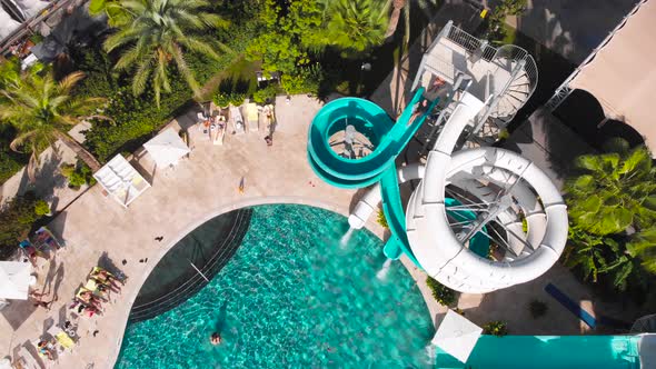 Fly Over a Large Pool with Blue Water and a Lot of Tourists in Hot Weather