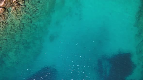 Aerial view of turquoise and clear sea water surface at sunny day