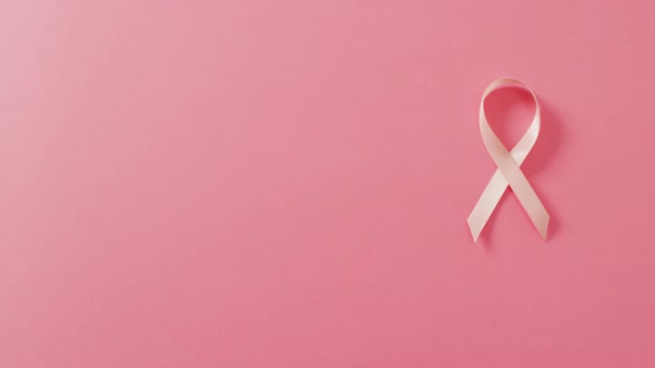 Video of pale pink breast cancer ribbon on pink background
