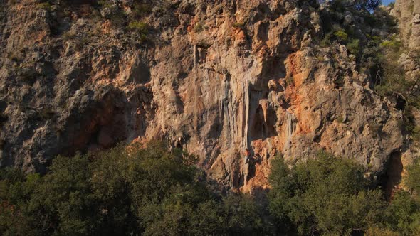 Aerial Slow Motion Footage From Drone of Man Rock Climber Hanging on Rope and Rappelling Through the