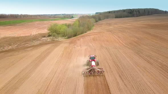 Shooting From Drone Flying Over Tractor with Harrow System