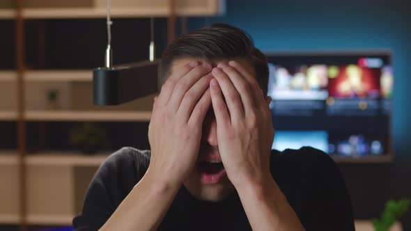 Close-up Portrait of Scared Man Bulging Eyes and Covering Mouth in Fright Reacting on Horrible