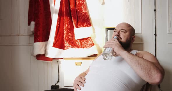 Concept of Bad Santa Claus Man Actor Drinks Alcohol in Dressing Room While Wait