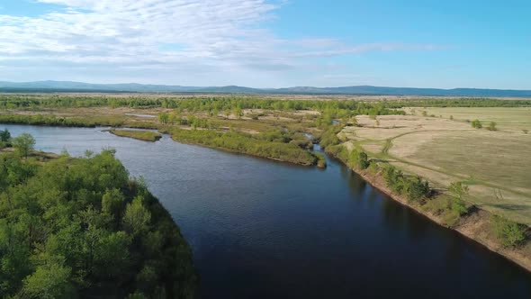 Aerial View of a River Flowing Through Rural Area with Meadows Rare Trees