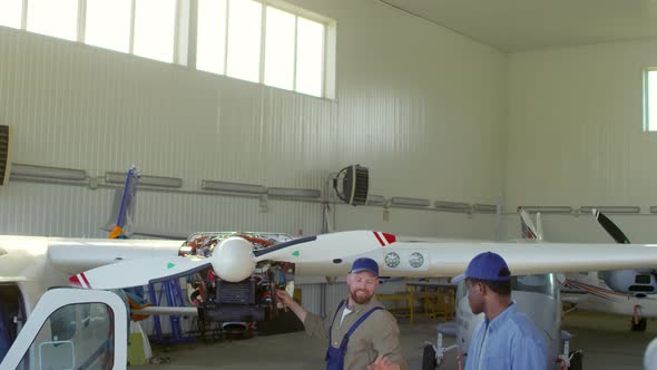 Aircraft Mechanics Fixing Propeller on Plane