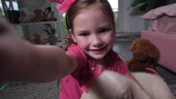 Portrait of Child Taking Selfie with Puppy at Home