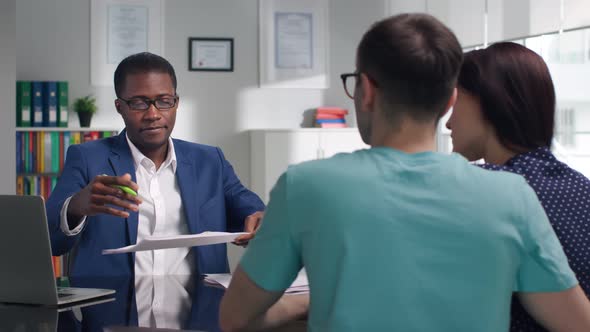 Civil Servant Advising Young Couple in Modern Office