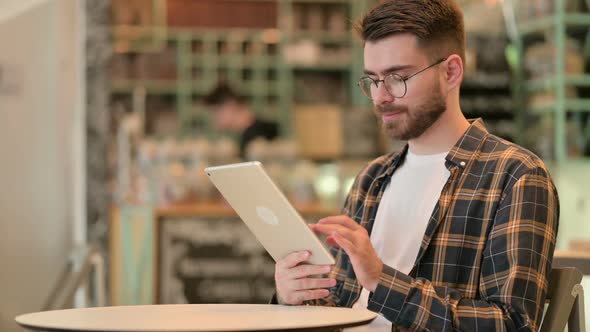 Professional Young Man Using Tablet in Cafe