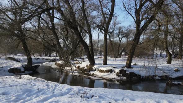 The Drone Flies Low Above The Ground From The River Bank. 