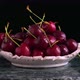 Fresh red sweet cherries in bowl. Ripe wet cherry berries rotate on black. - VideoHive Item for Sale