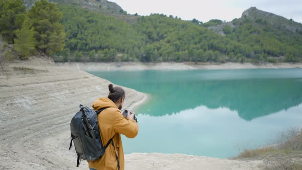 Young Man Walks Into Frame and Photographs Spanish Lake and Forest