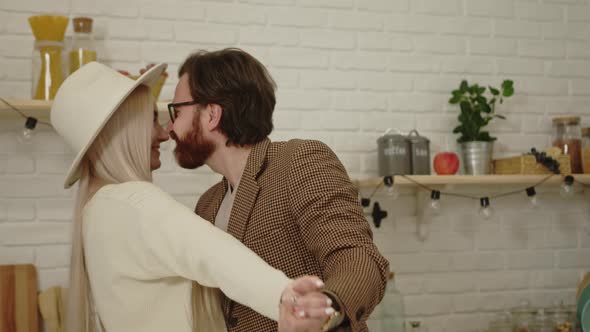 Portrait of Young European Husband Dancing with His Beautiful Longhaired Wife in the Kitchen