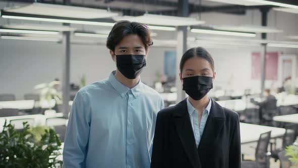 Japanese Female And Male Colleagues Wearing Masks Posing In Office