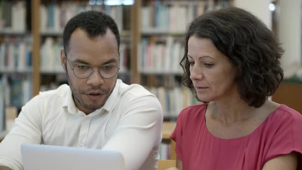 Two People Sitting at Library and Talking