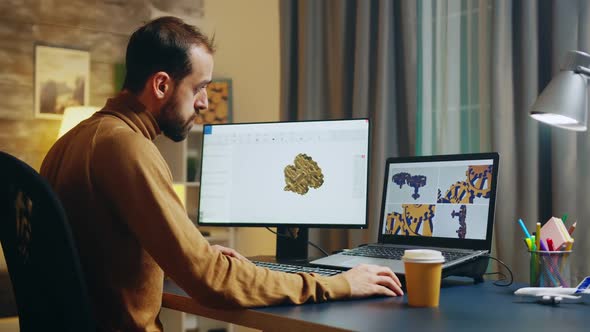 Bearded Engineer Taking a Sip of Coffee While Working on Computer